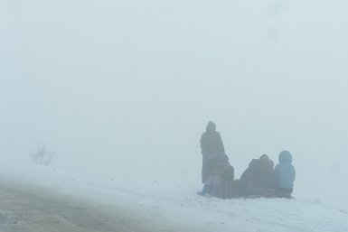 07800F2015___00640 Route de Tawang, 4000m, femmes de la BRO chargées de jeter un peu de terre sur la neige et rassemblées autour d'un petit feu de bois......