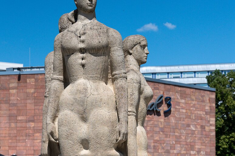 Passage par Chemnitz Groupe de 3 personnages dénommés Dignité humaine, Beauté et Fierté de l'homme sous le socialisme , devant la mairie de Chemnitz, de Gerd Jaeger (1974)