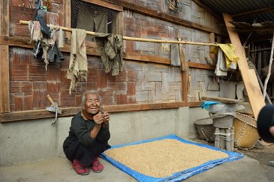 28900F2015___02624 Village de Hong, près de Ziro, Takhe Yanyer, plus familièrement Yanya, environ 90 ans, de la tribu apatani, prend le soleil en faisant sécher son riz.Les femmes...