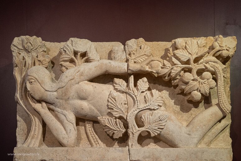 20210726__00152-2 Autun, musée Rolin: La Tentation d'Eve, 2e quart du XIIe s, sculpteur Gislebertus, Eve s'apprête à cueillir d'une main le fruit défendu présenté sur une branche...